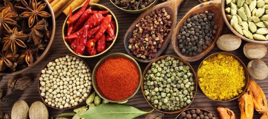 Spices and herbs in metal  bowls and wooden spoons. Food and cuisine ingredients.